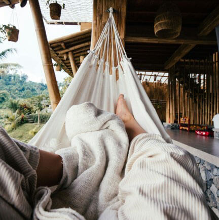 a person sits in a cozy hammock