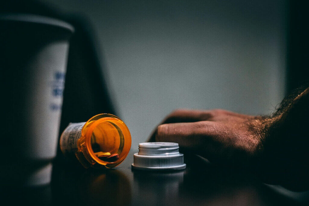 a pill bottle lies open on a countertop