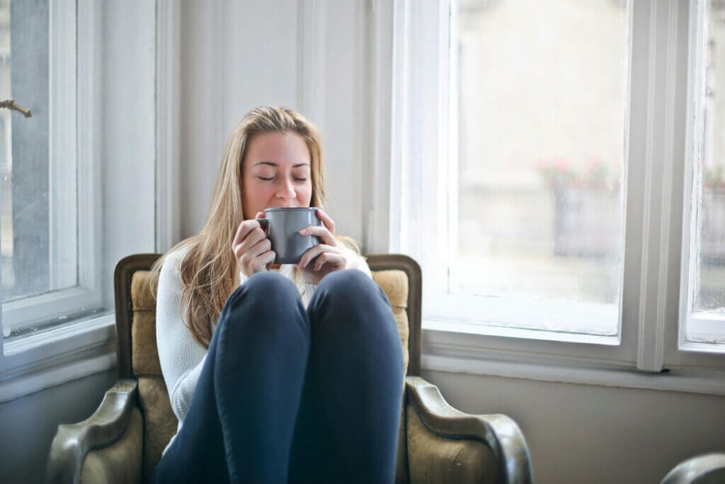 A woman sitting in a chair holding a mug.