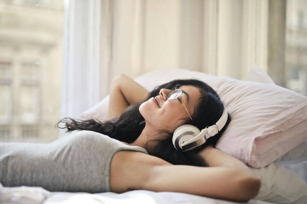 A woman with headphones on, immersed in listening to music, enjoying a moment of relaxation and focus.