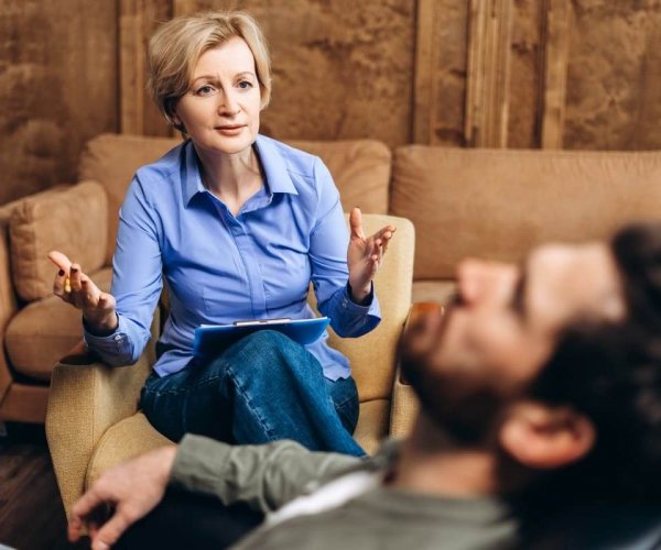 adult-female-psychiatrist-talking-to-young-bearded-2025-03-21-21-08-31-utc