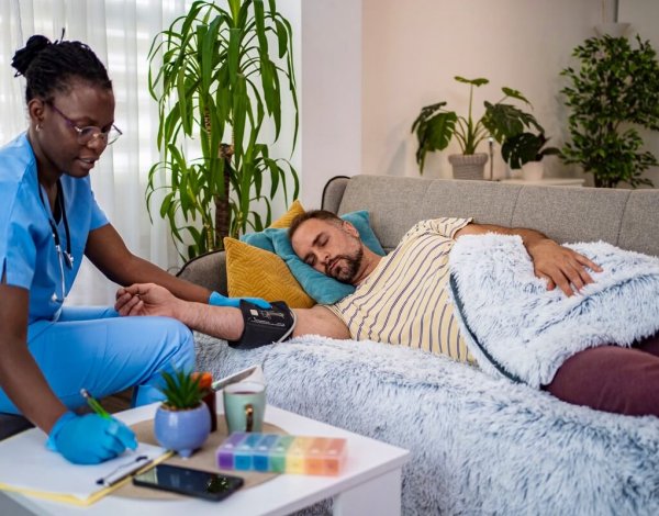 Nurse checks vital signs of relaxed patient in cozy setting.